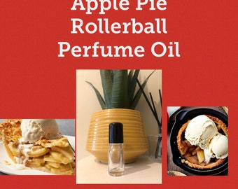 May include: A clear glass rollerball bottle with a black cap filled with apple pie scented perfume oil. The bottle is sitting on a yellow textured surface.
