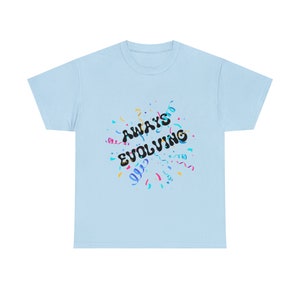 Puede incluir: Camiseta azul claro con el texto "ALWAYS EVOLVING" en negro, rodeada de confeti de colores.