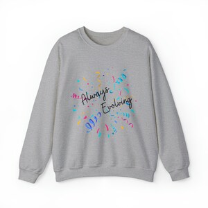 Puede incluir: Una sudadera gris con el texto "Always Evolving" en letra negra rodeada de confeti de colores.