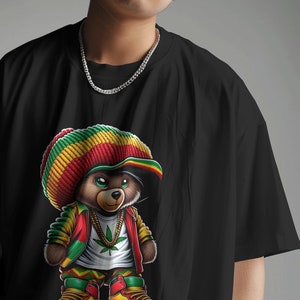 Puede incluir: Camiseta negra con una ilustraci&oacute;n de dibujos animados de un oso con un sombrero rojo y verde, una chaqueta roja y zapatillas de deporte. El oso sostiene una hoja de marihuana.