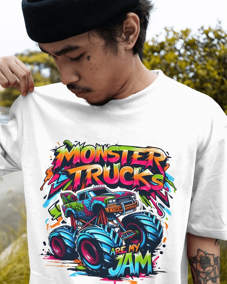 May include: White t-shirt with a colorful graphic of a monster truck. The text "Monster Trucks Are My Jam" is written in a graffiti style.