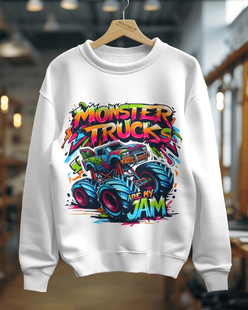 May include: White sweatshirt with a colorful graphic of a monster truck with the text "Monster Trucks Are My Jam".