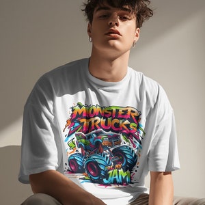 May include: A white t-shirt with a colorful graphic of a monster truck. The graphic includes the text "Monster Trucks Are My Jam".