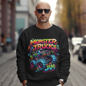 May include: Black sweatshirt with a colorful graphic of a monster truck. The graphic includes the text "Monster Trucks Are My Jam".