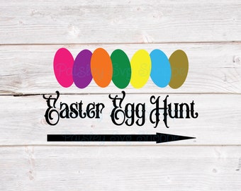 May include: A sign with the text "Easter Egg Hunt" in black script font with a black arrow pointing to the right. Above the text are seven colorful eggs in a row: pink, purple, orange, green, yellow, blue, and brown.