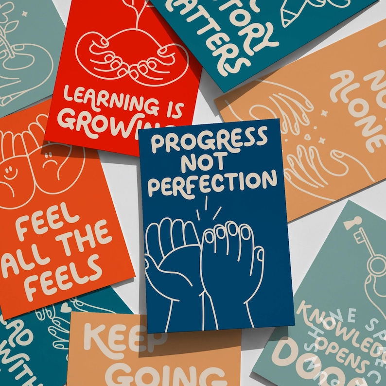 May include: A collection of colorful cards with motivational phrases and illustrations. The cards feature text like "Progress Not Perfection," "Feel All The Feels," and "Learning is Growing." The designs include hand-drawn images and a variety of bright colors.