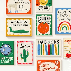 Pu&ograve; includere: Una collezione di stampe artistiche incorniciate con illustrazioni colorate e frasi motivazionali. Le stampe presentano una variet&agrave; di disegni, tra cui un cane, un coccodrillo, una palla da discoteca, un cactus, un arcobaleno e un'arancia sorridente. Il testo include "Piccoli passi, grandi guadagni" e "Amo i libri."