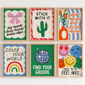Pu&ograve; includere: Sei stampe artistiche incorniciate con citazioni motivazionali e illustrazioni colorate. Le stampe presentano un fiocco, un cactus, fiori, un arcobaleno, una palla da discoteca e faccine sorridenti. Ogni stampa ha una cornice in legno.