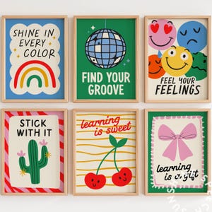 Pu&ograve; includere: Sei stampe artistiche incorniciate con frasi motivazionali e illustrazioni colorate. Le stampe includono un arcobaleno, una palla da discoteca, faccine sorridenti, un cactus, ciliegie e un fiocco rosa. Le frasi includono "Shine in Every Color" e "Find Your Groove."