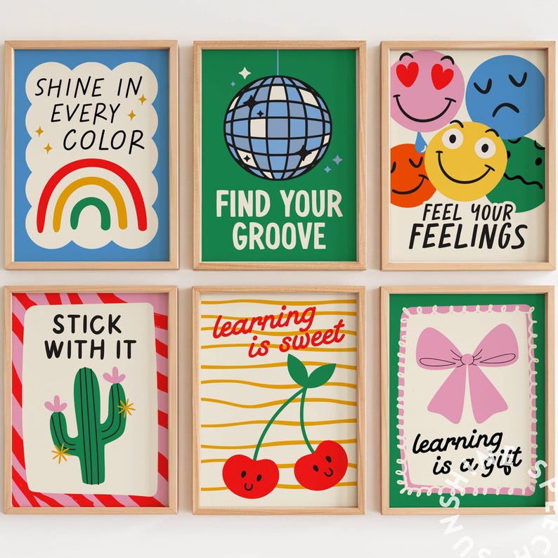 Pu&ograve; includere: Sei stampe artistiche incorniciate con frasi motivazionali e illustrazioni colorate. Le stampe includono un arcobaleno, una palla da discoteca, faccine sorridenti, un cactus, ciliegie e un fiocco rosa. Le frasi includono "Shine in Every Color" e "Find Your Groove."