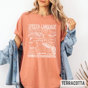 Oversized comfort colors retro-inspired shirt for speech therapist or SLPA with speech therapy scope of practice images on it and the words "All communication is valid." Gift for SLPs.