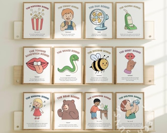 May include: A set of twelve framed educational posters with illustrations and text describing various sounds. The posters are arranged on wooden shelves. Each poster features a different sound, such as popcorn, vacuum, or singing.