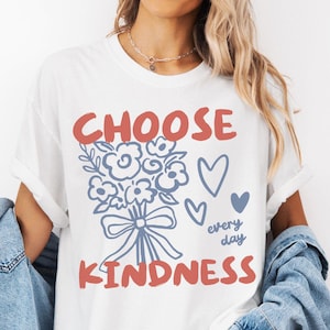 Comfort colors 1717 shirt that says Choose Kindness in large bold hand written font and has doodle images of a bouquet of flowers with a bow and hearts and the words every day written smaller in doodle cursive.