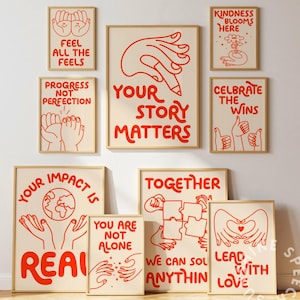 以下が含まれることがあります： クリーム色の背景に、赤いインスピレーションを与える引用句とイラストが描かれた額入りのアートプリントのコレクションです。「Your Story Matters」、「Lead With Love」、「Feel All The Feels」などのフレーズが特徴です。
