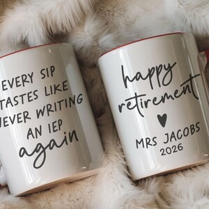 May include: Two white ceramic mugs with red handles and rims. One mug reads "EVERY SIP TASTES LIKE NEVER WRITING AN IEP again." The other mug says "happy retirement" with a heart and "MRS JACOBS 2026."