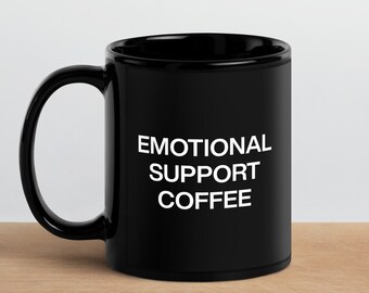 May include: Black ceramic coffee mug with white text that reads "Emotional Support Coffee".
