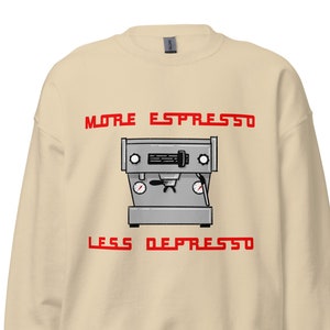 May include: A beige sweatshirt with the text "More Espresso Less Depresso" in red. A cartoon image of an espresso machine is in the center of the sweatshirt.