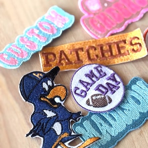 May include: A collection of embroidered patches in various shapes and colors. Includes a patch with a cartoon bird, a patch that says "Game Day" with a football, and patches with the words "Patches" and "Houston".