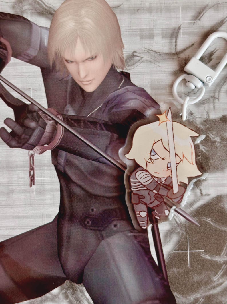 May include: A white keychain with a silver clasp and a cartoon character charm. The character is a blonde woman with a sword, wearing a grey and white outfit. The charm is attached to a black and silver chain.