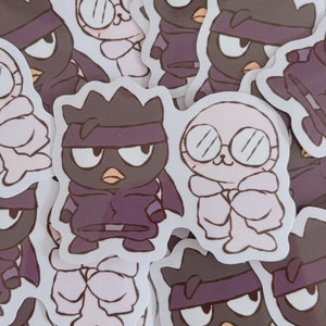 May include: A set of stickers featuring a black and white cartoon character with a purple bandana and a white cartoon character with glasses. The stickers are on a white background.