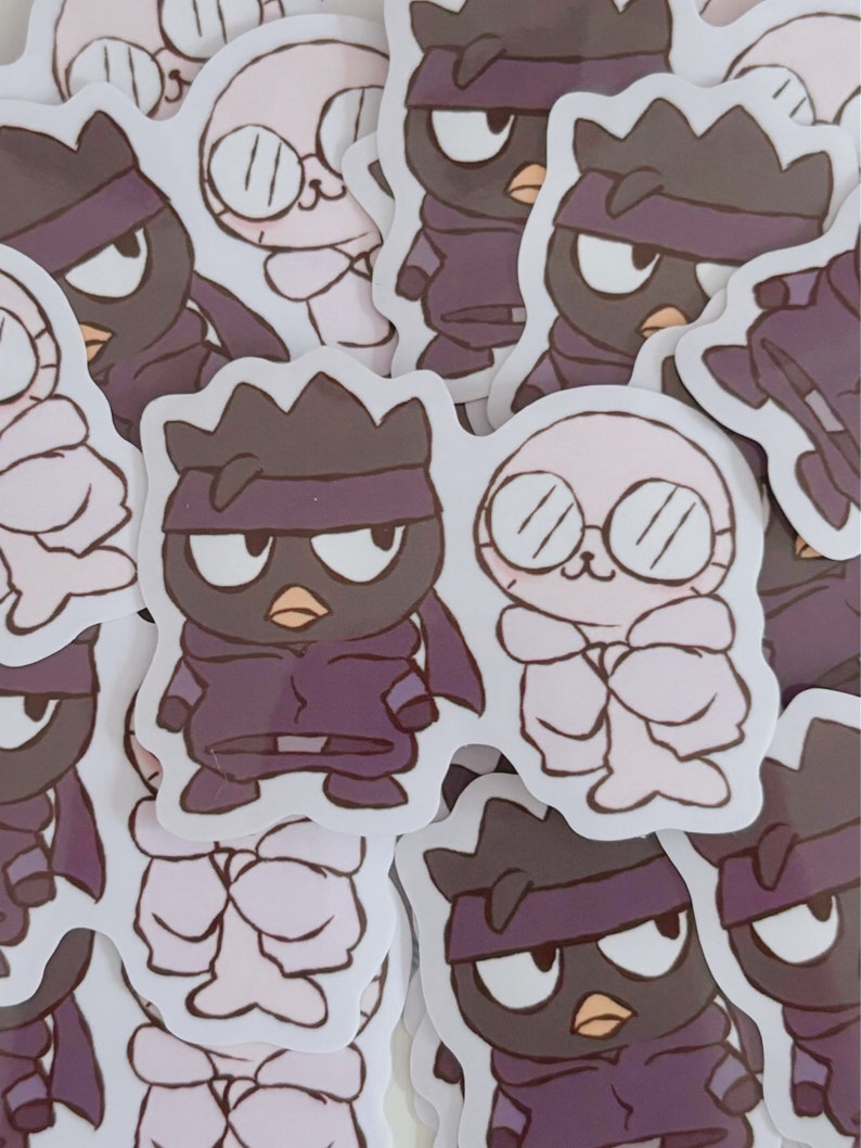May include: A set of stickers featuring a black and white cartoon character with a purple bandana and a white cartoon character with glasses. The stickers are on a white background.
