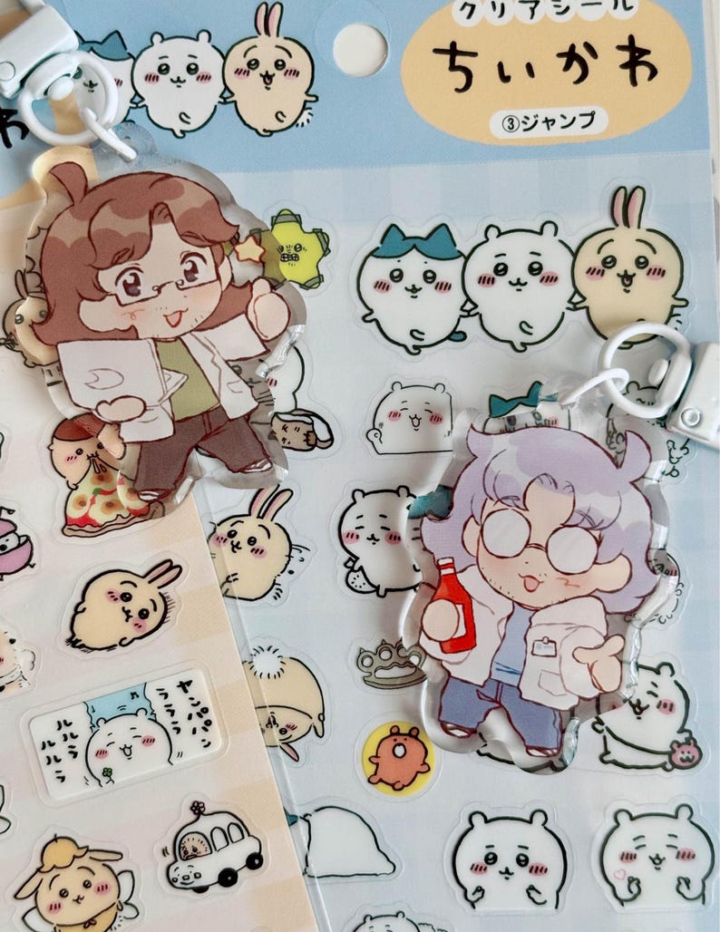 May include: Two clear acrylic charms featuring cartoon characters with glasses and white lab coats. The characters are holding a clipboard and a bottle of ketchup. The charms are surrounded by smaller stickers of cartoon animals and objects. The text on the packaging reads "ウリ デー ル ちい が お ③ シャンプ".