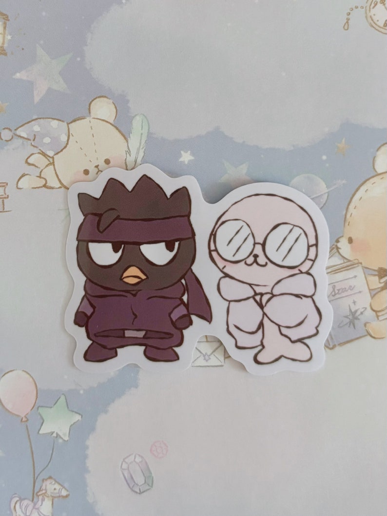 May include: Two cartoon stickers, one of a purple ninja with a black mask and the other of a pink seal wearing glasses and a white coat.