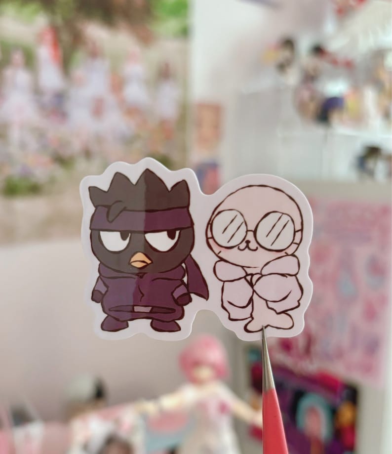 May include: Two cartoon stickers, one black and one white. The black sticker is of a bird wearing a purple ninja outfit and a black mask. The white sticker is of a white bird wearing a white coat and glasses.