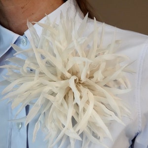 Bloemenbroche van zijde. Bloemspeld. Crèmewitte kleur. Verpakt als cadeau