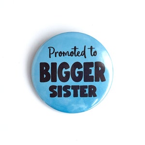 May include: A blue button with the text "Promoted to BIGGER SISTER" in black.
