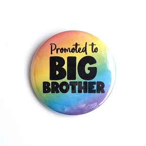 May include: A rainbow-colored button with the text "Promoted to Big Brother" in black.