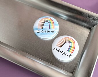 May include: Two round white buttons with a rainbow and the text "He died for all".