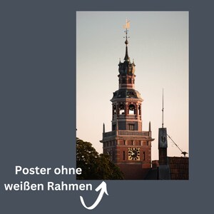 Pode incluir: Uma alta torre de tijolo vermelho com um rel&oacute;gio e um telhado pontudo. A torre &eacute; coroada por uma catavento e tem uma s&eacute;rie de janelas arqueadas. A torre est&aacute; contra um c&eacute;u azul claro.