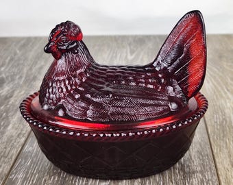 Gallina de cristal rojo rubí sobre un nido tejido, tapada con un plato de dulces: ¡brilla en la oscuridad!