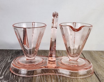 Azucarero y cremera abiertos de cristal rosa estilo Art Déco con diseño floral y cazoleta.