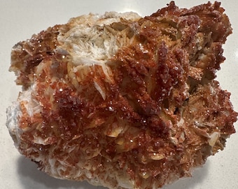 May include: A cluster of red and white barite crystals with a rough, textured surface.