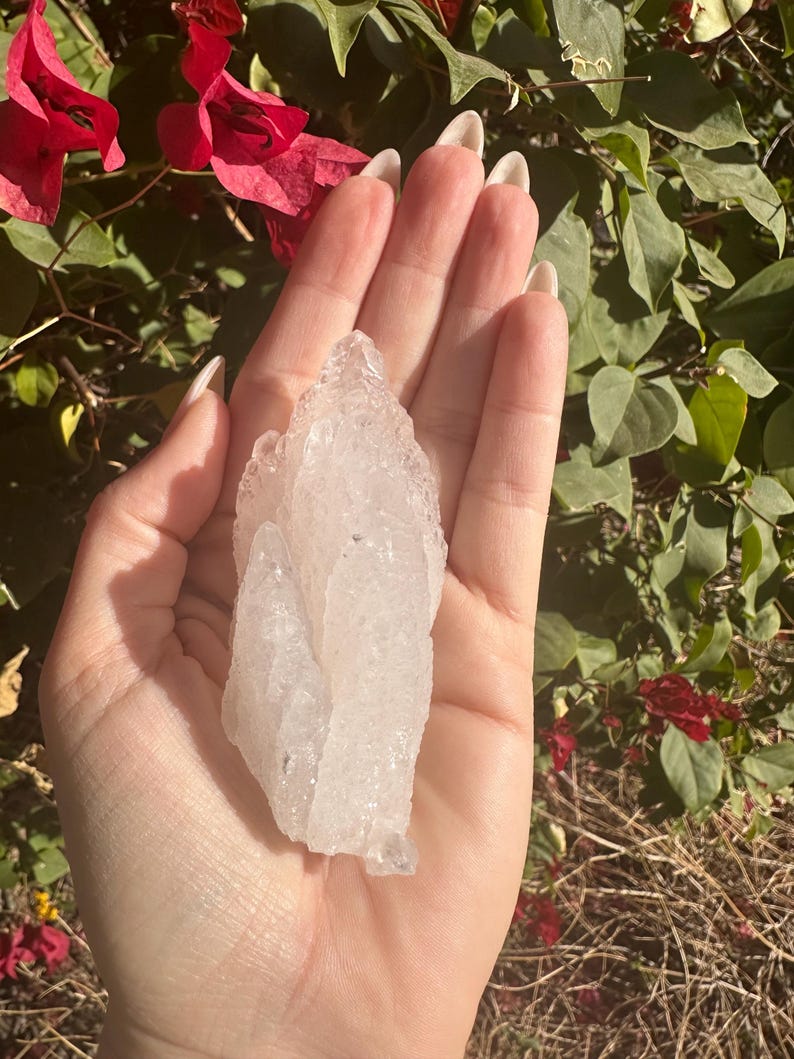 Puede incluir: Un gran c&uacute;mulo de cristal de cuarzo transparente con una textura rugosa y natural. El cristal es transl&uacute;cido y tiene un color blanco lechoso.