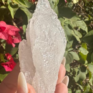 Puede incluir: Un c&uacute;mulo de cristales de cuarzo transparentes con una superficie rugosa y texturizada. Los cristales est&aacute;n agrupados en una formaci&oacute;n &uacute;nica, creando una forma natural y org&aacute;nica.