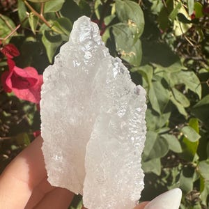 Puede incluir: Dos grupos de cristales de cuarzo blanco con una superficie rugosa y texturizada. Los cristales son transl&uacute;cidos y tienen una forma natural y org&aacute;nica.