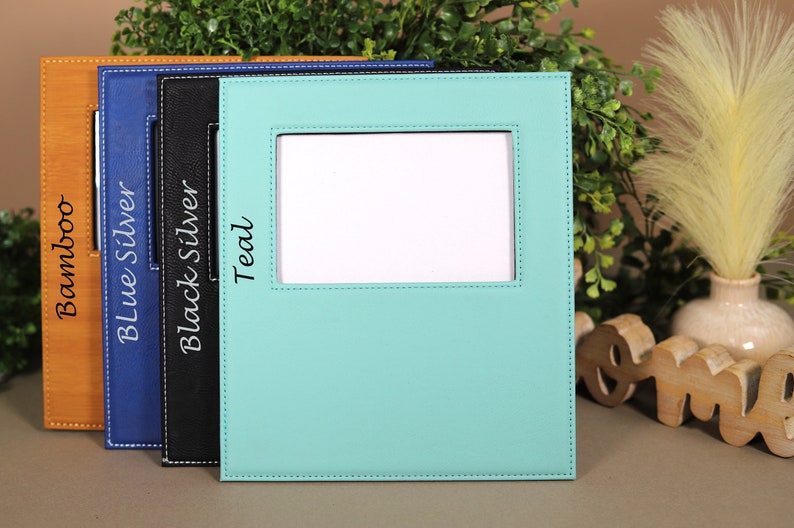 May include: Four picture frames in different colors: bamboo, blue silver, black silver, and teal. Each frame has a stitched border and a white rectangle in the center.