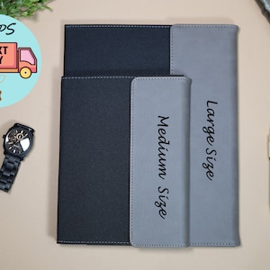 May include: Two black and gray leather notebook covers with the words "Medium Size" and "Large Size" printed on them.