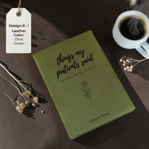 K&ouml;nnte beinhalten: Ein Set aus drei Keramikbechern mit einer gesprenkelten, cremefarbenen Glasur. Jeder Becher hat ein anderes handgemaltes Design: ein blaues und gr&uuml;nes Blatt, eine gelbe Blume und eine rote Beere. Die Becher haben eine einfache, abgerundete Form.