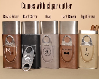 May include: Five different colored leather cigar cases with a built-in cigar cutter. The cases are lined with stainless steel and have a variety of personalized engravings. The colors are rustic silver, black silver, gray, dark brown, and light brown.
