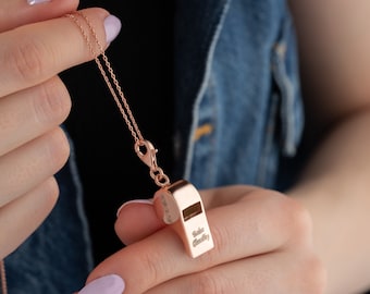May include: A rose gold necklace with a whistle pendant. The whistle is engraved with the words "Take a Breather".