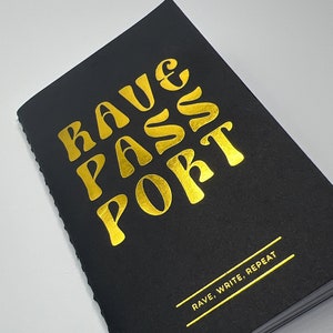 May include: A black notebook with gold foil lettering that reads "Rave Passport" and the phrase "Rave, Write, Repeat" on the bottom.