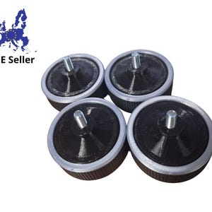 Könnte beinhalten: Vier runde schwarze Möbelfüße mit einer silbernen Schraube in der Mitte. Jeder Fuß hat einen silbernen Rand.