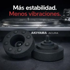 Peut inclure: Accessoires noirs pour platine vinyle avec le texte "Más estabilidad. Menos vibraciones." Une platine vinyle noire est en arrière-plan. Les accessoires comprennent une pièce ronde avec de petits cercles et une pièce avec une base texturée.