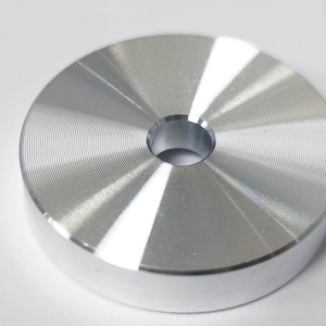 Peut inclure: Un poids de disque en métal argenté avec un trou central. Le poids a une surface lisse et polie avec des cercles concentriques.