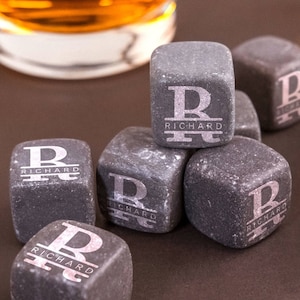 May include: Eight gray stone whiskey chilling cubes with the letter "R" and the name "Richard" engraved on each cube.