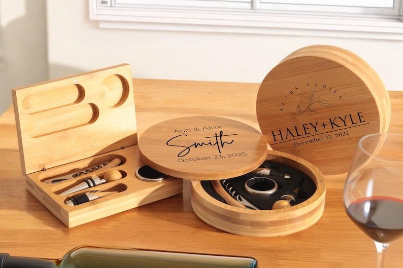 May include: Two wooden boxes with engraved text. One box is round and has the text "Haley + Kyle" and "December 12, 2022". The other box is rectangular and has the text "Ash & Alex Smith" and "October 23, 2025".
